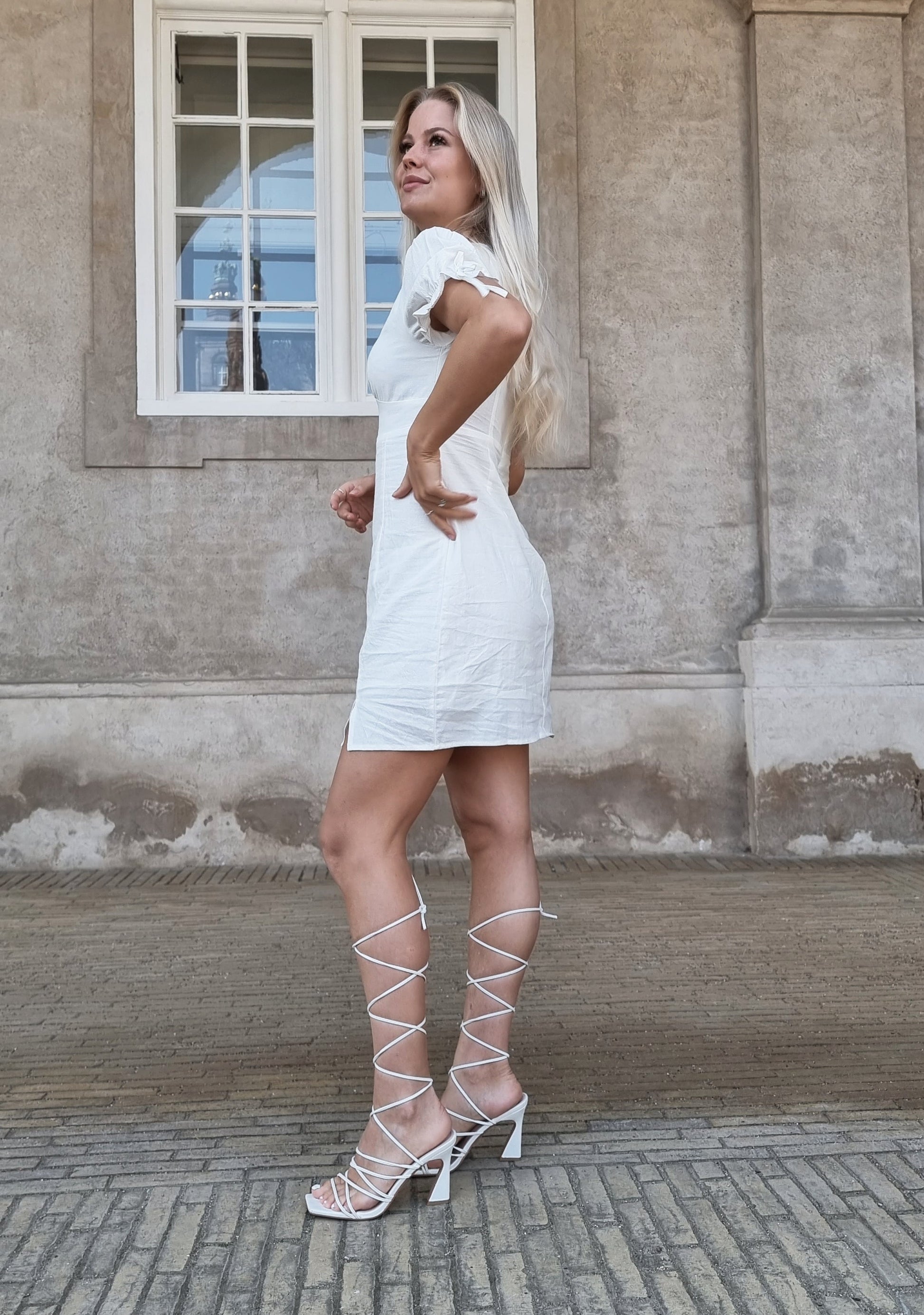 Model i Elenza hvid kjole med pufærmer og slids (0138) fra webshoppen Aaberg Copenhagen